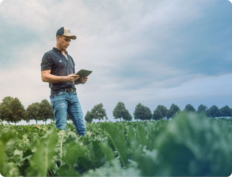 Farmer in a field holding a iPad